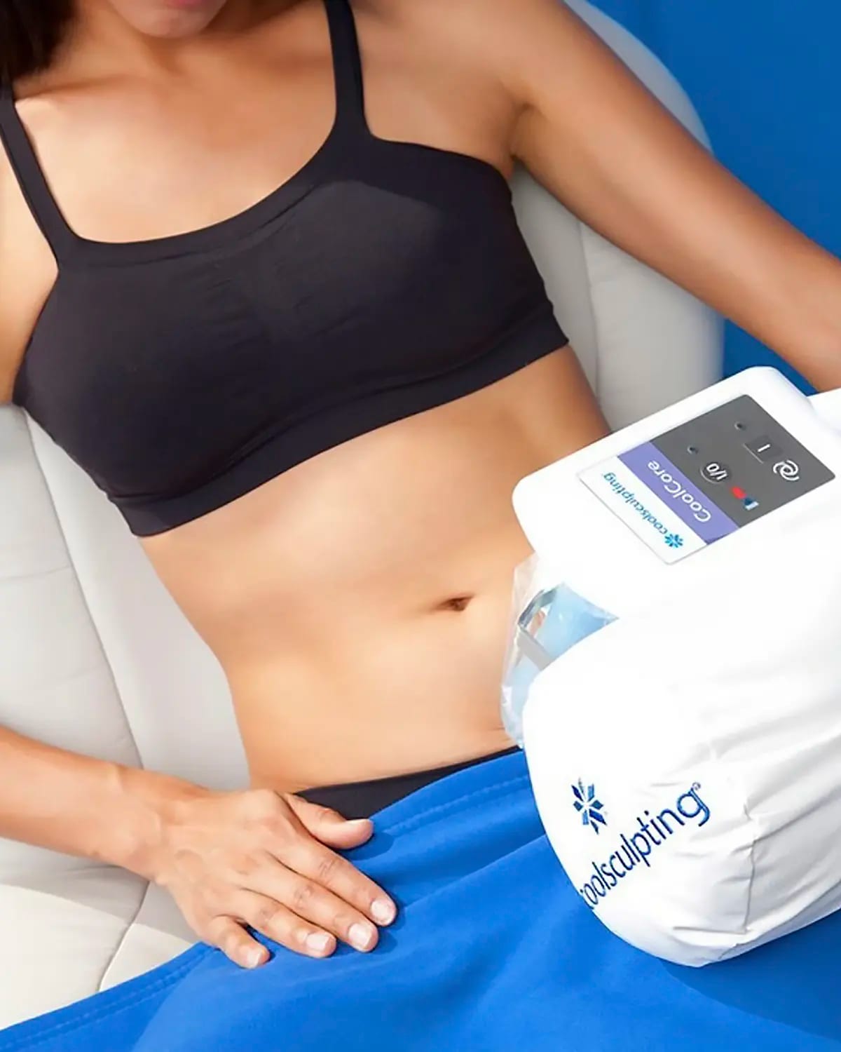 Photograph of a model: a CoolSculpting applicator rests on a woman's abdomen