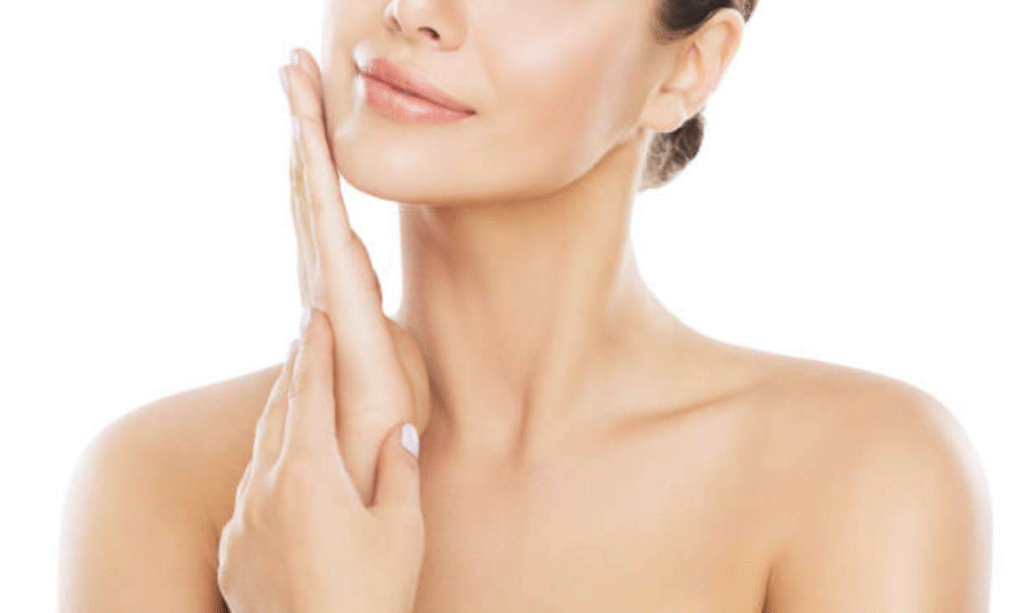 Photograph of a model: a woman's bare shoulders and neck, her hands raised to her chin